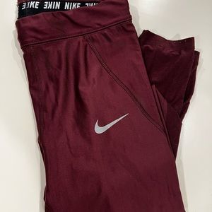 Size S Maroon Nike dri-fit running leggings w/leg pocket and mesh accent.